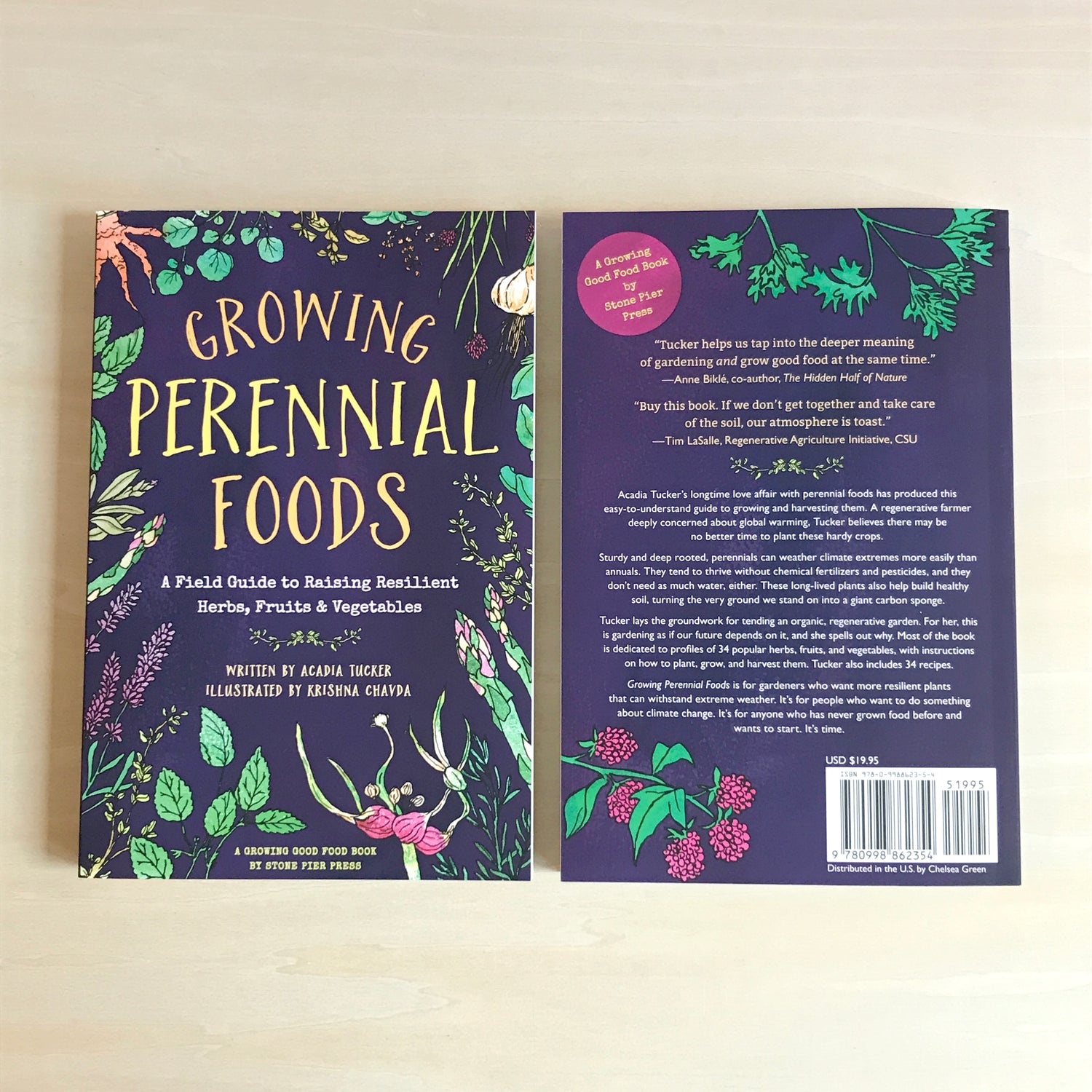 Photo of two copies of the books "Growing Perennial Foods: A Field Guide to raising resilient herbs, fruits, & vegetables" by Arcadia Tucker. The book on the left shows the front of the book, the book on the right shows the back of the book.