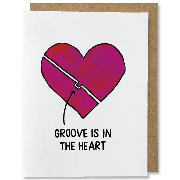 Illustrated love greeting card of a pink-red heart split into two with a diagonal line creating a cutout in the bottom part of the heart, top part of heart has a nub that fits into the cutout. Caption reads "groove is in the heart" with a black arrow pointing to the cutout.